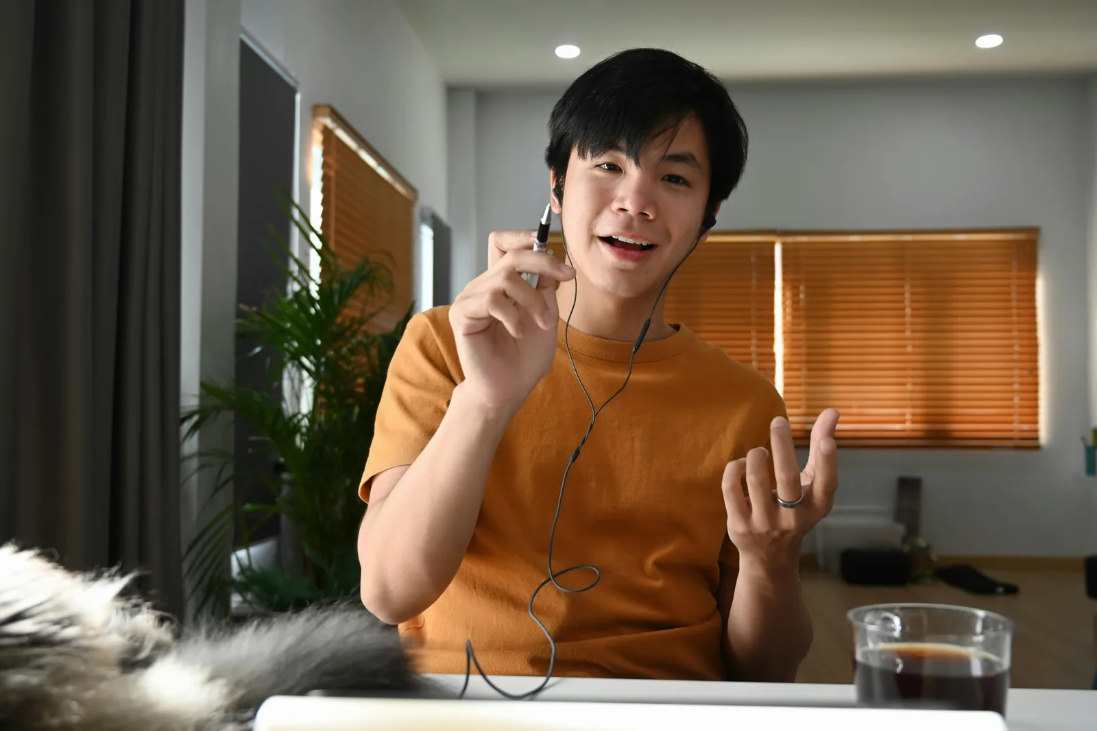 ผู้ชายพูดหน้ากล้องในห้องที่เปิดไฟเพดาน
