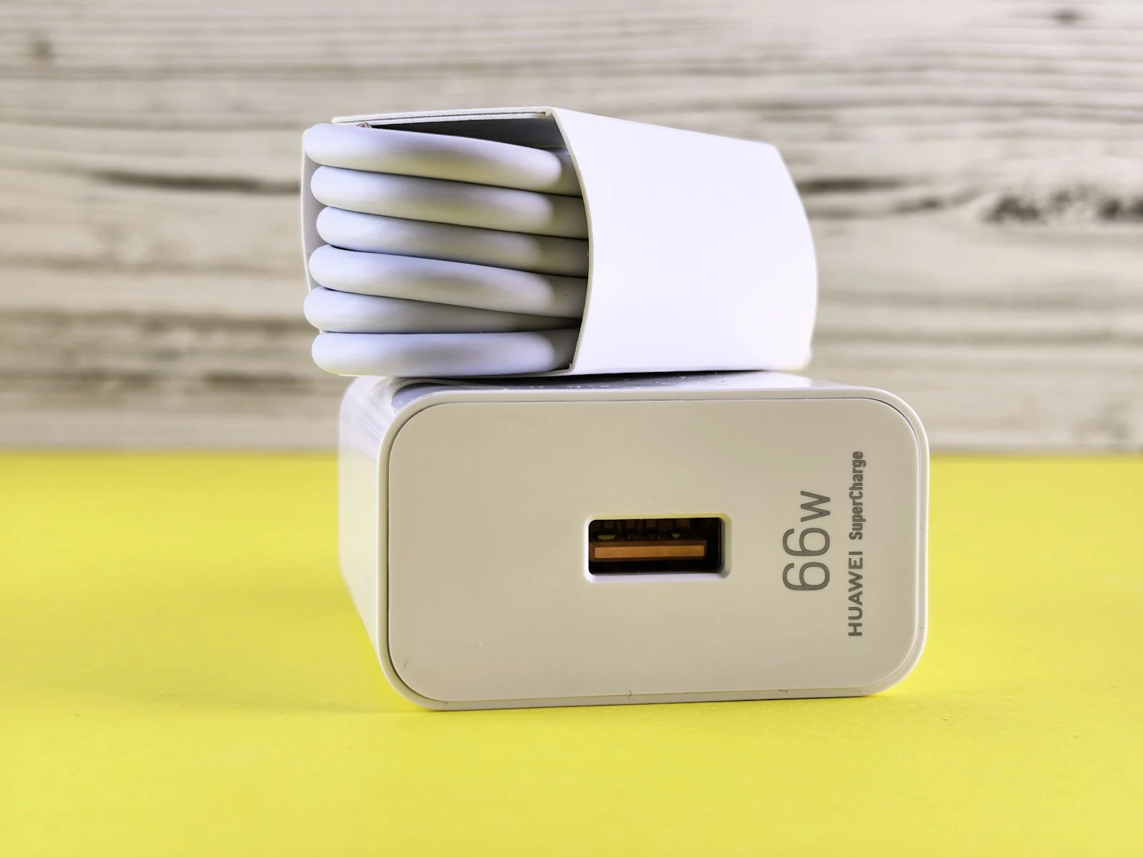 หัวชาร์จ USB วางบนโต๊ะ ใช้เป็นแหล่งไฟให้แบตดัมมี่