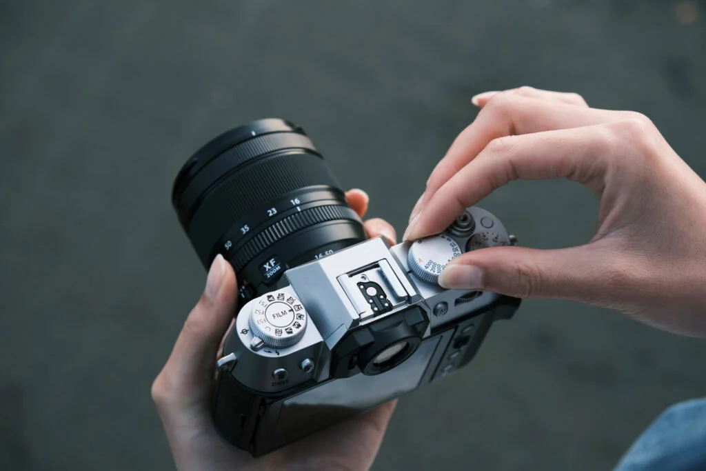 ปุ่มหมุน FUJIFILM บนกล้อง X-T50 สีเงิน ขณะมือกำลังหมุนปรับค่า