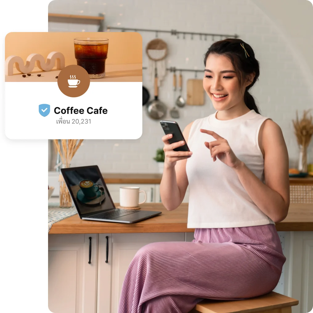 เจ้าของร้านกาแฟยิ้มดูมือถือ มีกรอบชื่อร้านบน LINE OA ซ้อนอยู่ในภาพ