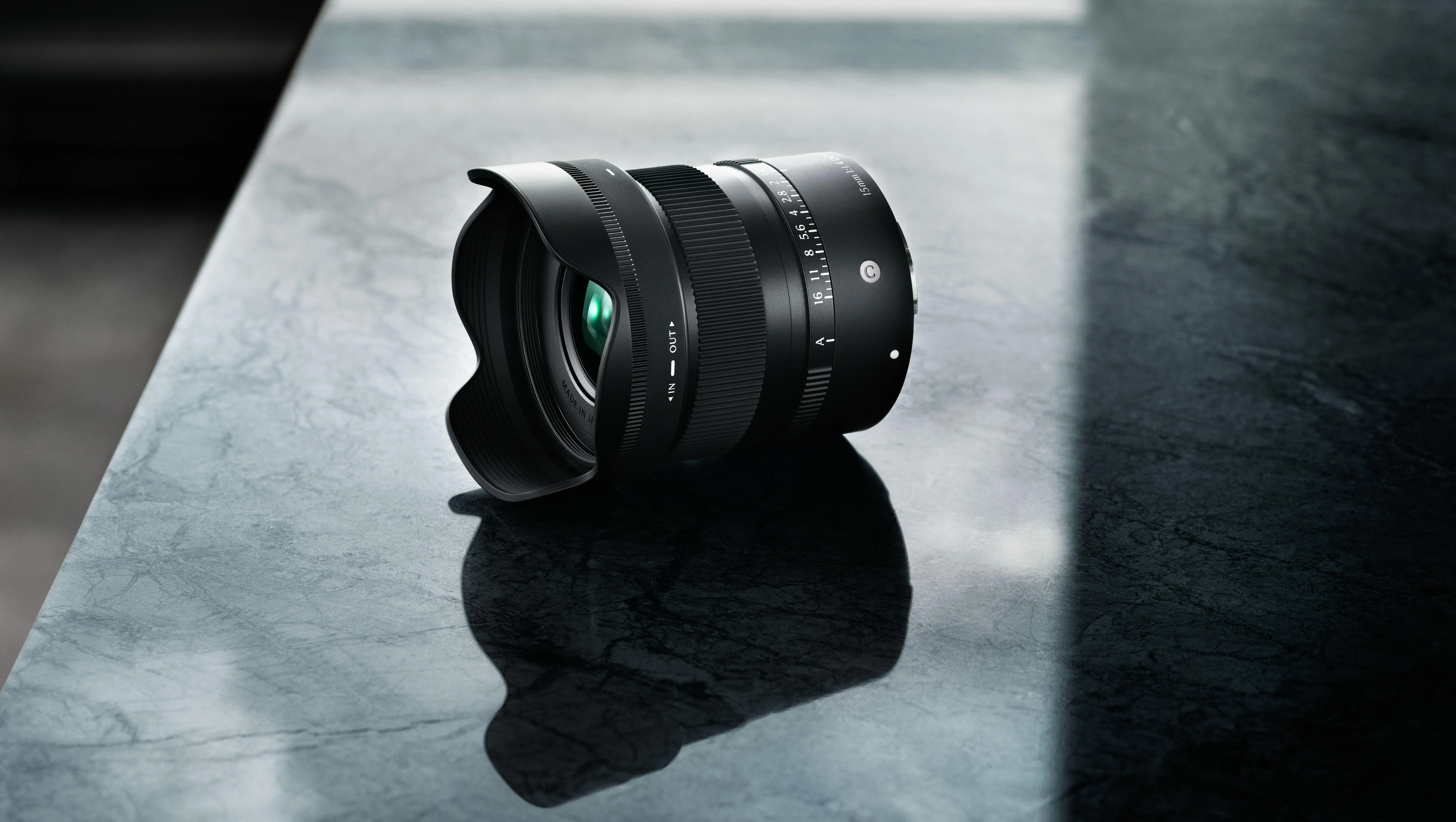 SIGMA 15mm F1.4 DC Contemporary วางบนโต๊ะหินอ่อนสีเข้ม