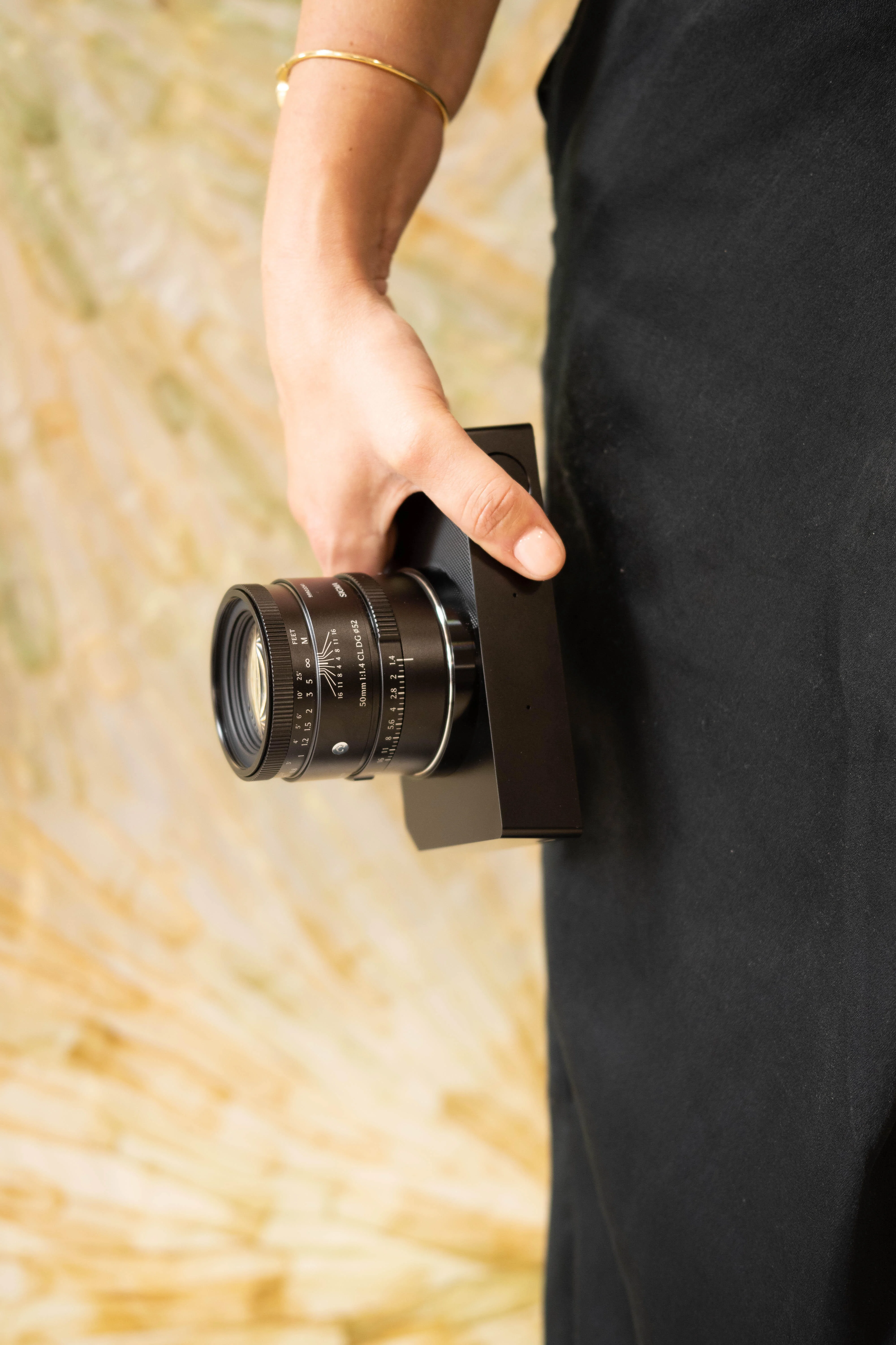 SIGMA 50mm F1.4 CL ติดกล้องอยู่ในมือช่างภาพ